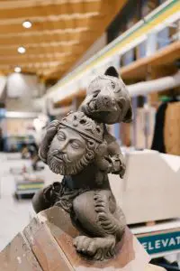 A grotesque statue of King Edmund, his head is being held in the paws of an intricately carved wolf.